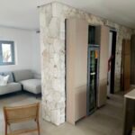 Reforma integral de vivienda en Palma: salón con columna revestida de piedra