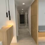 Pasillo de vivienda reformada con puertas de madera e iluminación colgante
