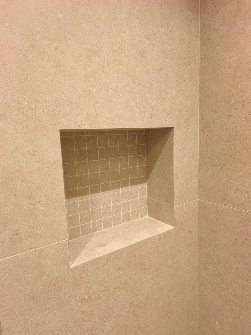 Nicho de ducha de obra revestido con mosaico, integrado en el alicatado porcelánico de gran formato, en Palma