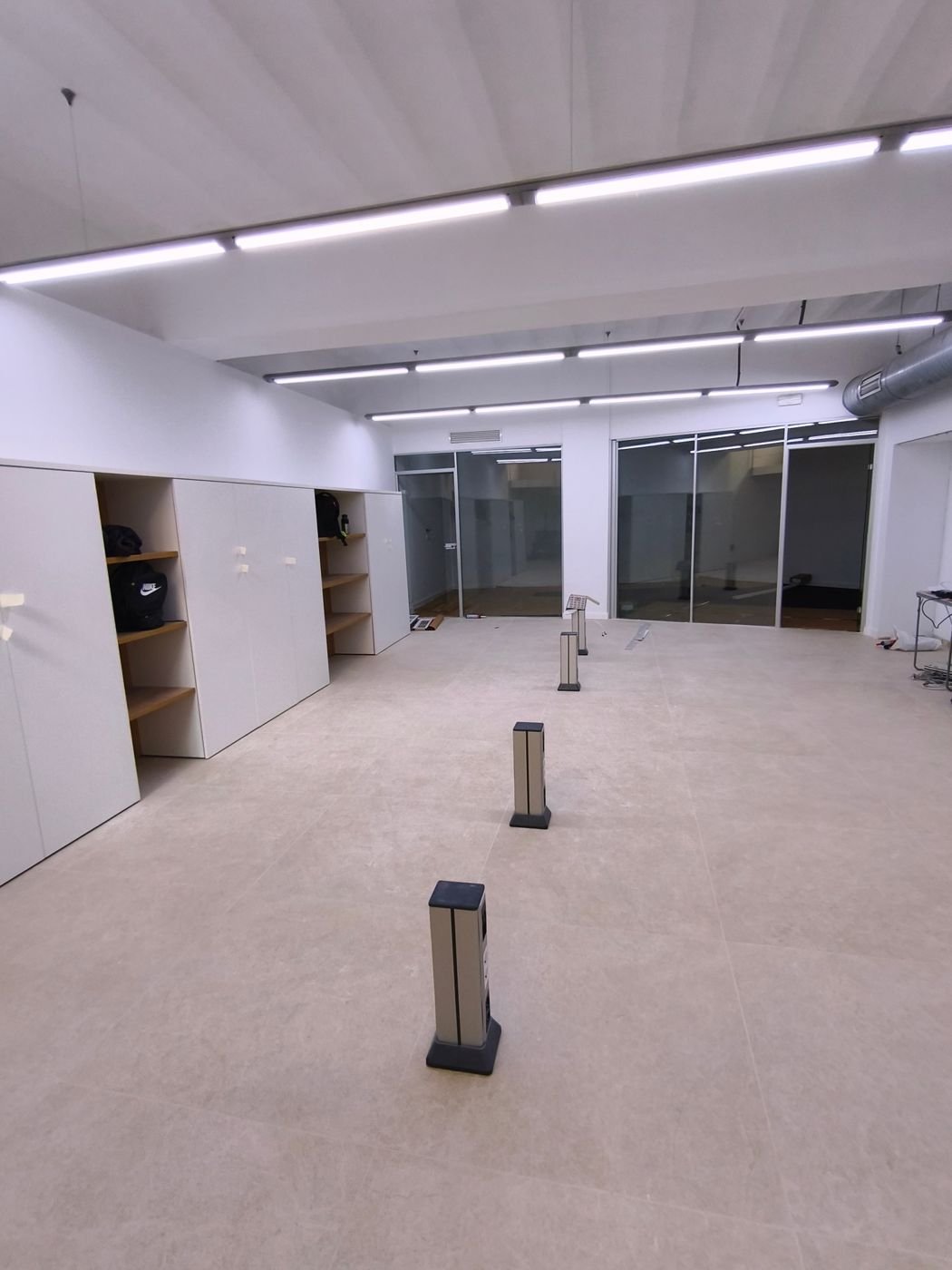 Local comercial reformado en Palma con suelo porcelánico de gran formato y torretas de enchufes – Faradays Building