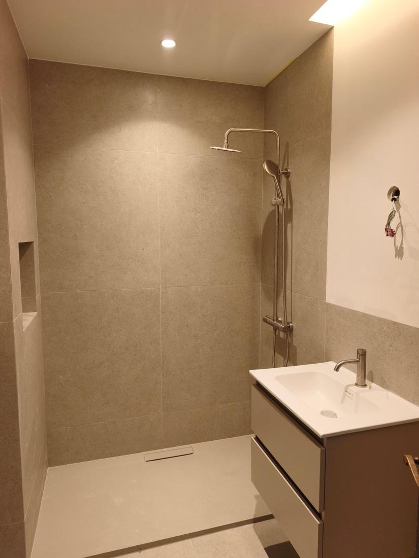 Baño reformado con ducha de obra, alicatado efecto piedra y mueble suspendido en Palma